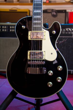 Photo for Solid black electric guitar Les Paul-style with humbucker pickups. - Royalty Free Image