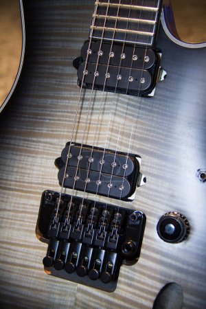 Foto de Primer plano de una guitarra eléctrica gris maciza con pastillas humbucker y hardware pickguard negro. - Imagen libre de derechos
