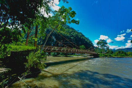 Foto de Puente colgante en la selva sobre el río de montaña - Imagen libre de derechos