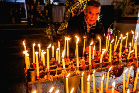 Téléchargez les photos : Le 22 février 2016 - Huancayo, Pérou : un homme allume des bougies dans l "église d'iglesia Chongos Bajo - en image libre de droit