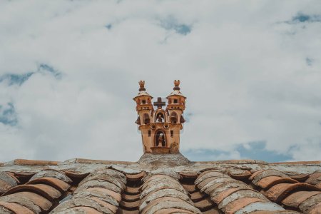 Schöne Aufnahme eines Hausdaches mit Kirchenminiatur oben über bewölktem Himmel 
