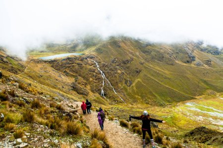 Téléchargez les photos : Femme avec sac à dos marchant sur le sentier dans les montagnes - en image libre de droit