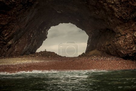 Photo for A beautiful shot of a rock in the sea under a cloudy sky Paracas Peru - Royalty Free Image