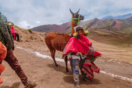Téléchargez les photos : Homme avec son lama en montagne de couleurs, Cusco Pérou - en image libre de droit