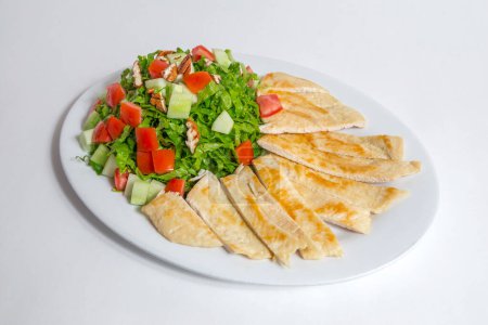Photo for Salad with fresh chicken meat, vegetables, greens, tomatoes, lettuce on a white plate, top view - Royalty Free Image