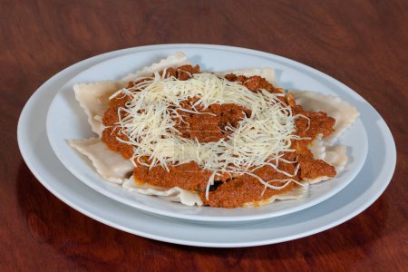 Foto de Plato de comida italiana con ravioles de tomate con queso. - Imagen libre de derechos