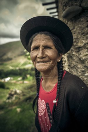 Téléchargez les photos : Une femme en robe traditionnelle avec un chapeau et un sac à dos sur la tête - en image libre de droit