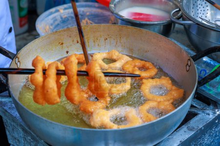 Téléchargez les photos : Picarones péruviennes, un délicieux dessert à base de farine de blé mélangée à la citrouille et, parfois, la patate douce, baigné de miel de chancaca. C'est un plat traditionnel de la gastronomie péruvienne. - en image libre de droit