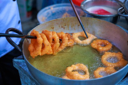 Téléchargez les photos : Picarones péruviennes, un délicieux dessert à base de farine de blé mélangée à la citrouille et, parfois, la patate douce, baigné de miel de chancaca. C'est un plat traditionnel de la gastronomie péruvienne. - en image libre de droit