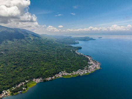 Foto de Vista de pueblos en la costa del lago y la montaña con selva, bosque, palmeras en Lanao del Sur. Mindanao, Filipinas. - Imagen libre de derechos