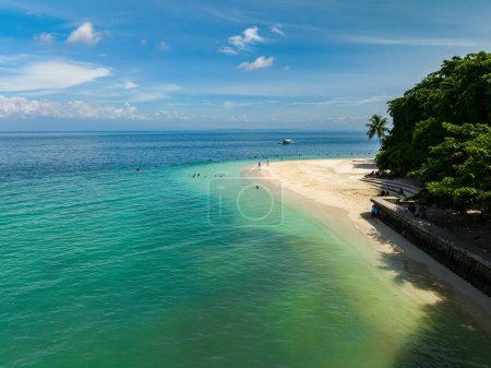Foto de Hermosa playa de arena con olas en la costa. Gente y barco sobre el agua turquesa. Playa Kaputiana. Samal Island. Davao, Filipinas. - Imagen libre de derechos