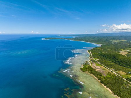 Foto de Isla tropical con costa de arena blanca y hermosas olas en la costa. Cielos azules y nubes. Mindanao, Filipinas. - Imagen libre de derechos