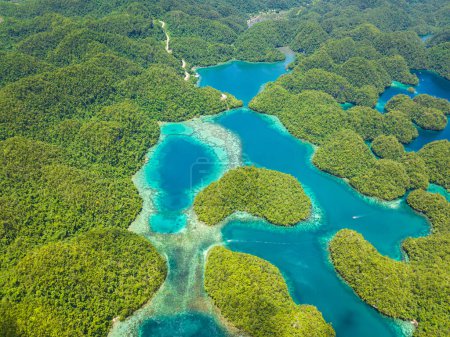 Vista aérea de la isla con colinas de selva tropical y agua azul en laguna con nubes. Sohoton Cove. Bucas Grande Island. Mindanao, Filipinas.
