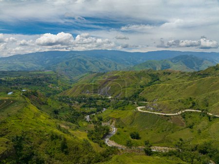Téléchargez les photos : Forêt tropicale avec eau courante au-dessus de la rivière. Vallée de montagne avec route asphaltée. Mindanao, Philippines. - en image libre de droit