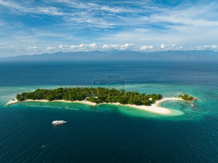 Weißer Sand rund um die Insel. Boot über das blaue Meer, den blauen Himmel und die Wolken. Samal Island. Davao, Philippinen.