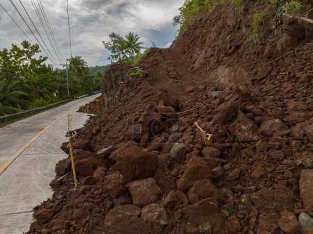 Mountain landslide due to heavy rainfall. Mud abd rocks in the rightside of the road. Philippines.