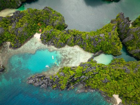 Téléchargez les photos : Bateau et kayaks au-dessus de l'eau turquoise claire. Petite lagune de l'île Miniloc. El Nido, Palawan. Philippines. - en image libre de droit