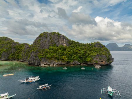 Tour boats and kayaks floating over the blue sea. Lagoons in Miniloc Island. El Nido, Palawan. Philippines.