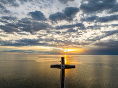 A large cross over the sea in Camiguin Island. Sunset with reflection background. Philippines.