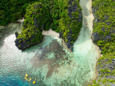 Reflejo solar sobre agua transparente con kayaks en la isla de Miniloc. El Nido, Palawan. Filipinas.