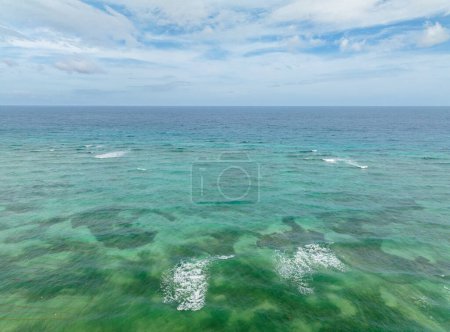 Ondas oceánicas y arrecifes de corales con agua turquesa. Mar azul en Santa Fe, Tablas, Romblon. Filipinas.