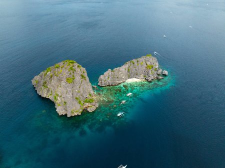 Blaues Meer mit Booten rund um Twin Rocks. El Nido, Palawan. Philippinen.