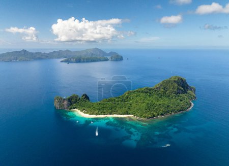 Helicopter Island with white sand beach. Boats over the blue sea. El Nido, Philippines.
