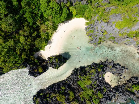 White sandy beach and clear waters in Hidden Beach. Matinloc Island. El Nido, Philippines.
