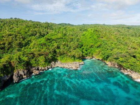 Coastline with turquoise sea water and waves on rocks. Carabao Island. San Jose, Romblon. Philippines.