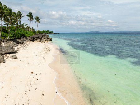 Téléchargez les photos : Cocotiers dans la plage de sable blanc avec des vagues de l'océan clair dans l'île de Carabao. San José. Romblon, Philippines. - en image libre de droit