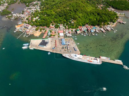 Drohnen-Ansicht von Coron Port mit Fähre und türkisfarbenem Wasser. Coron, Palawan. Philippinen.
