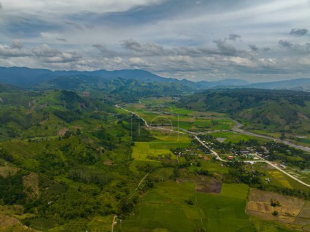 Téléchargez les photos : Collines verdoyantes avec des rizières et de l'eau qui coule sur les rivières. Ciel bleu et nuages. Mindanao, Philippines. - en image libre de droit