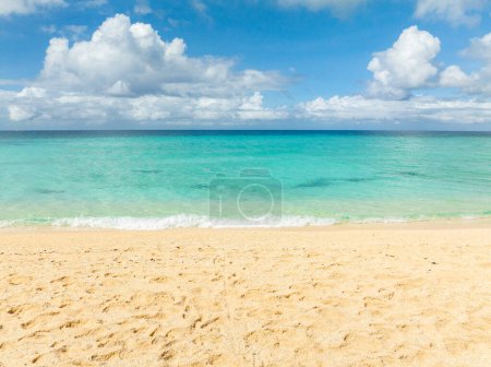 Ocean waves on sandy beach. Blue sky and clouds. Puka Beach. Boracay, Philippines.