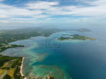Terres agricoles dans une île tropicale avec de l'eau de mer turquoise et des vagues. Santa Fe, Tablas, Romblon, Philippines.
