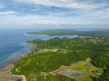 Île tropicale avec collines verdoyantes et terres agricoles. Eau turquoise sur la côte. Santa Fe, Tablas, Romblon. Philippines.