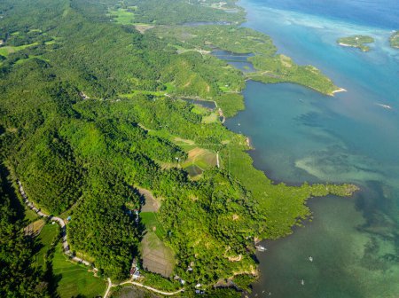 Bosque verde y agua de mar turquesa en la isla tropical. Santa Fe, Tablas, Romblon. Filipinas.