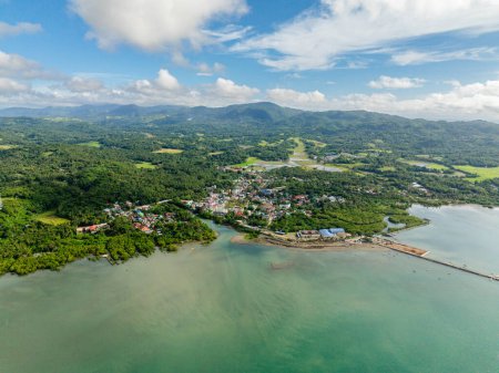 Drone view of Looc Poblacion with residential area at coast and pier. Tablas Island. Romblon, Philippines.