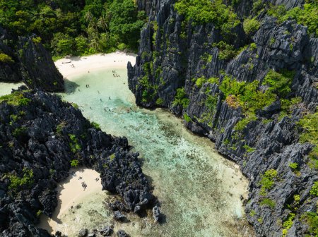 Klares Wasser mit Korallen und weißem Sand. Hidden Beach. Matinloc Island. El Nido, Philippinen.