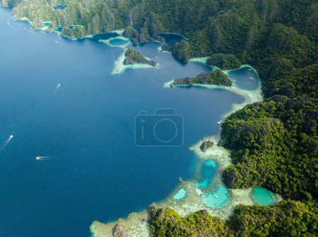 Lagoons with turquoise clear water and corals. Tour boats on blue sea. Coron, Palawan. Philippines.