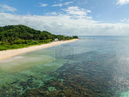Sea waves on white sandy beach with turquoise sea water and corals in Santa Fe, Tablas, Romblon. Philippines.