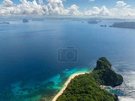 Tropischer Strand mit Meereswellen und Booten. Helikopterinsel. El Nido, Philippinen.
