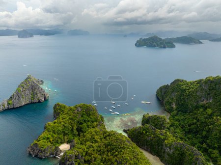 Boats and Kayaks over the blue sea. Miniloc and Twin Rocks in El Nido, Palawan. Philippines.