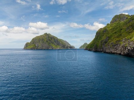 Mar azul e islas bajo cielo azul y nubes en El Nido. Tapiután y Matinloc. Filipinas.