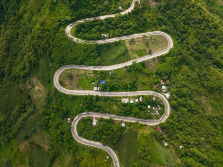 Téléchargez les photos : Véhicules circulant sur la route de l'intestin et les collines dans la province montagneuse de Bukidnon. Mindanao, Philippines. - en image libre de droit