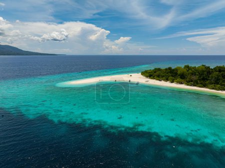 Plage de sable blanc sur l'île de Mantigue. Eau turquoise claire et ciel bleu et nuages. Camiguin, Philippines.