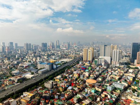 Autoroute avec des véhicules. Bâtiments en hauteur et quartier résidentiel. Metro Manila, Philippines.