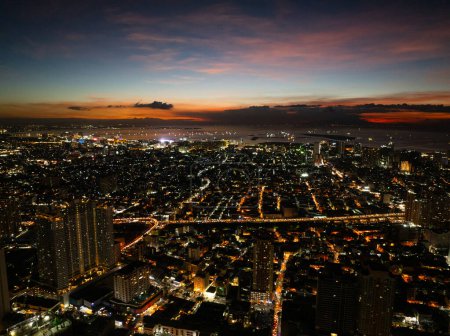 Küstenstadt bei Nacht mit farbenfrohen belebten Straßen mit Lichtern. Makati, Metro Manila. Philippinen.
