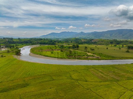 Aerial view of paddy farmlands and river on countryside. Mindanao, Philippines.