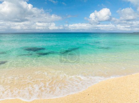 Beautiful inshore waves crashing on sands. Crystal clear waters. Blue sky and clouds. Puka Beach. Boracay, Philippines.