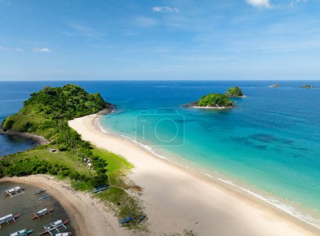 Beaches with boats and cream colored sands with ocean waves. El Nido, Palawan. Philippines.